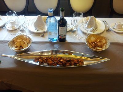 Detalle de mesa preparada con ración y botella de vino