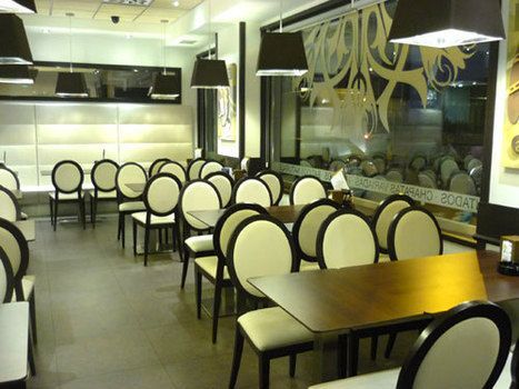 Interior de la cafetería con mesas y sillas