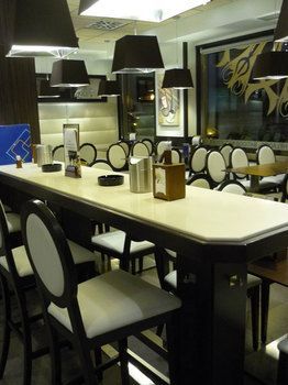 Interior de la cafetería con mesa y sillas altas