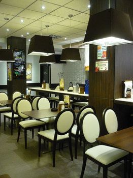 Interior de la cafetería con mesas bajas y sillas